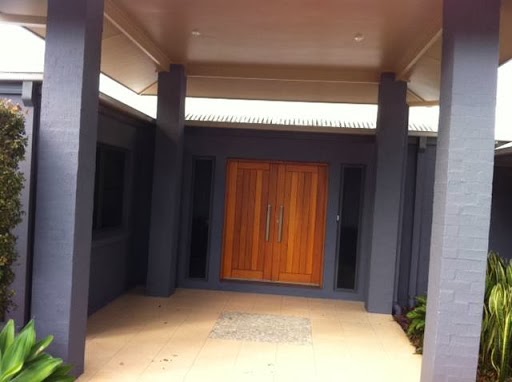 Home entry with charcoal painted columns framing a timber front door